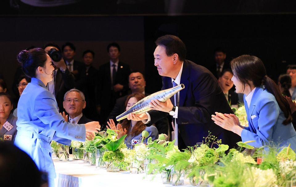 윤석열 대통령과 김건희 여사가 22일 서울 중구 신라호텔에서 열린 ‘2024 파리올림픽 선수단 격려 행사’에서 탁구 전지희 선수로부터 파리올림픽 선수들이 사인한 성화봉을 선물받고 있다.