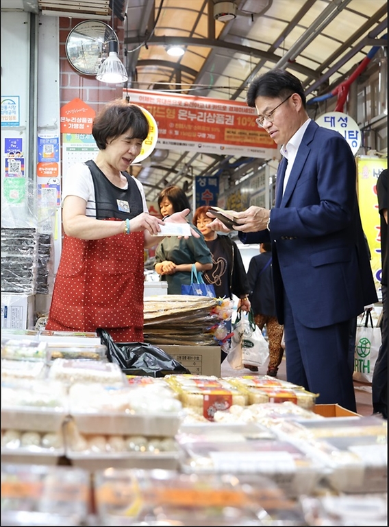 유국희 원자력안전위원회 위원장이 9일 서울 서대문구 독립문영천시장에서 물건을 구매하고 있다.