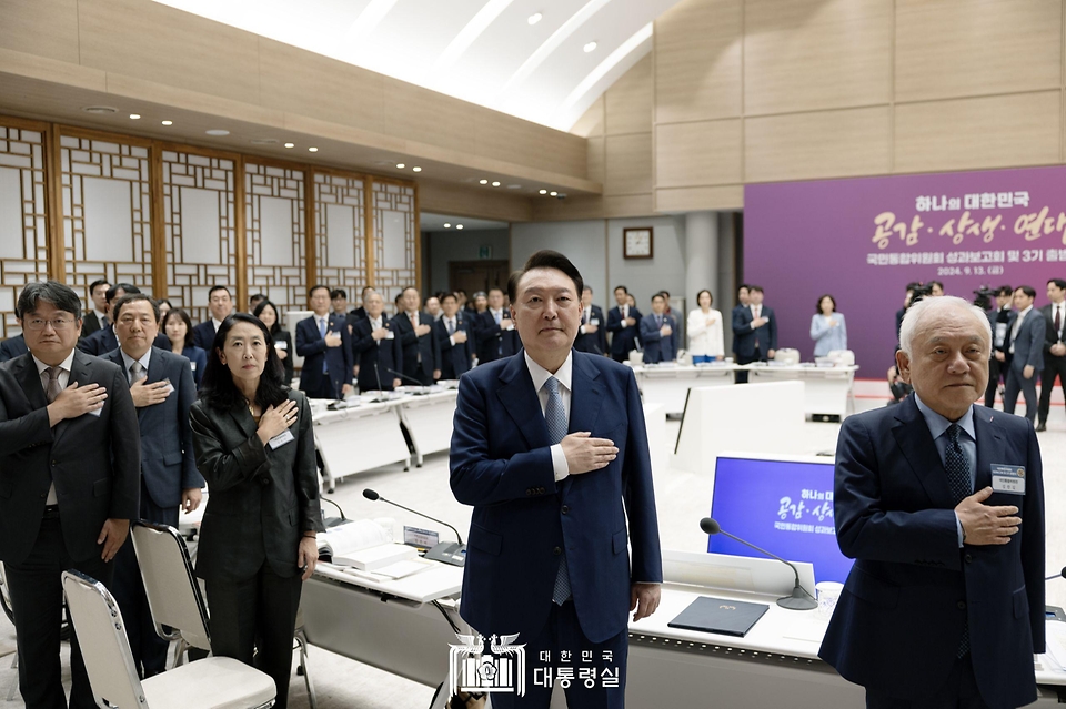 윤석열 대통령이 13일 서울 용산 대통령실 청사에서 열린 ‘국민통합위원회 성과보고회 및 3기 출범식’에서 참석자들과 함께 국기에 경례하고 있다.