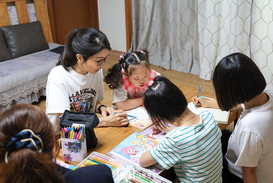 김건희 여사가 추석 연휴인 15일 서울 은평구 장애아동거주시설인 다움장애아동지원센터를 방문해 보조 교사와 함께 아이들이 그림책에 색연필로 색칠하는 것을 도와주고 있다.