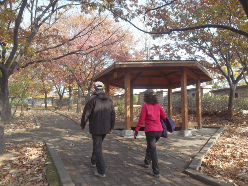 서울 한양도성 정상을 향해 오르는 길 주변 쉼터 옆을 한 부부가 나란히 걸어가고 있다. 