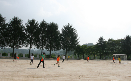 드림마을 운영진, 대학생 멘토, 참여 청소년까지 모두 운동장에 모여 축구를 하고 있다.