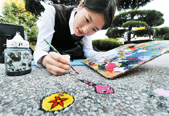 충북 보은고 2학년 박송이(17) 양이 교정 길바닥에 붙어 있는 껌딱지를 도화지 삼아 멋진 작품을 만들어내고 있다.