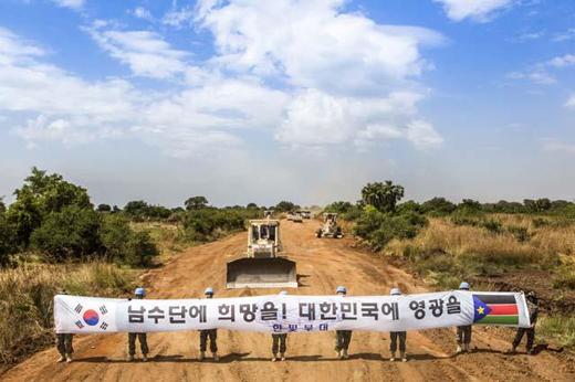 한빛부대 장병들이 주바~보르 간 도로 위에서 완공을 기념하는 플래카드를 들고 기념촬영을 하고 있다. (사진제공=합참)