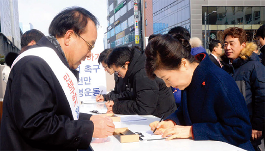 박근혜 대통령이 1월 18일 경기 성남시 차바이오컴플렉스에서 열린 6개 부처 업무보고를 마친 뒤 인근 판교역 광장의 ‘민생 구하기 입법 촉구 1000만 서명운동’ 행사장을 방문해 서명하고 있다.(사진=동아DB)