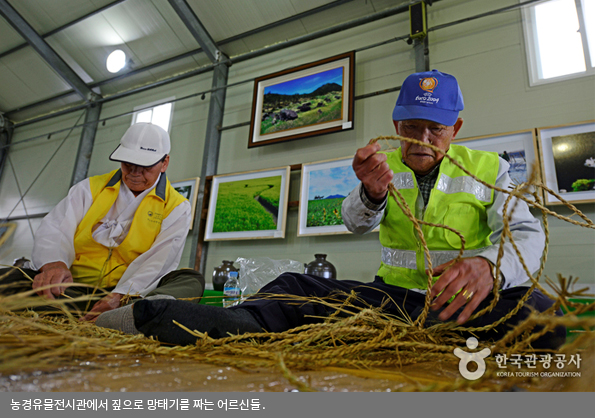 농경유물전시관에서 짚으로 망태기를 짜는 어르신들