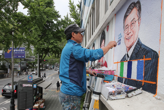 문재인 대통령 취임식이 열린 10일 오후 서울 종로구 선거연수원에서 한 관계자가 건물 외벽에 문 대통령 초상화를 그리고 있다. <저작권자(c) 연합뉴스, 무단 전재-재배포 금지>