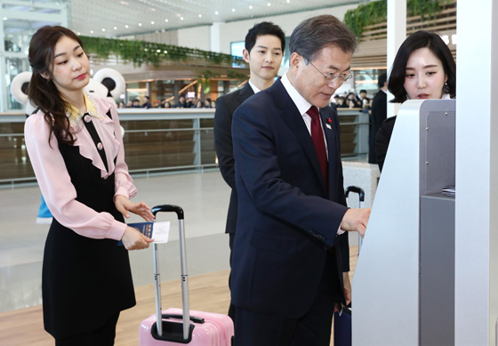 문재인 대통령이 12일 오후 인천국제공항 제2터미널 개장식 참석에 앞서 평창 홍보대사 김연아, 배우 송중기 씨와 함께 셀프 체크인을 하며 스마트 공항 체험을 해보고 있다. 