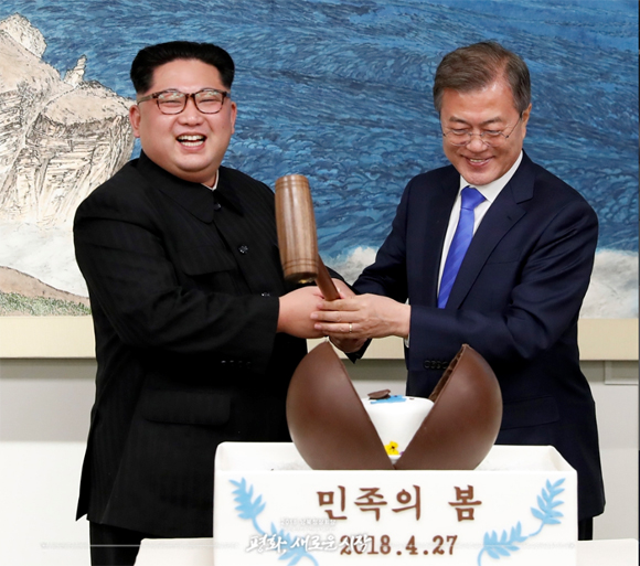 지난 4월 27일 오후 문재인 대통령과 김정은 국무위원장이 함께 나무망치를 들고 디저트인 초콜릿 원형돔 ‘민족의 봄’을 열고 있다. <제공=공동취재단>