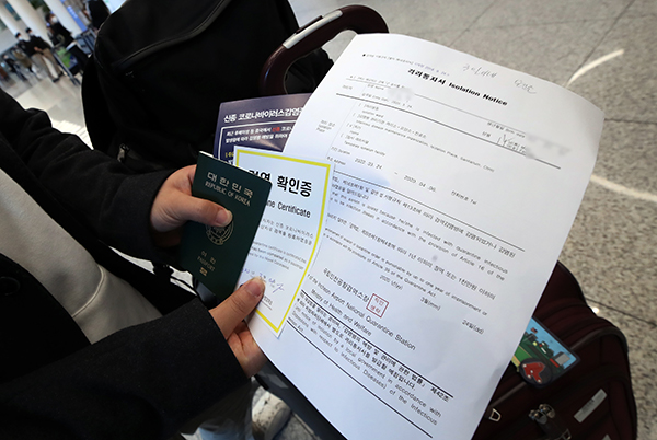 영국 런던발 입국자가 24일 오후 인천국제공항 2터미널에서 격리통지서와 검역확인증을 들고 공항 입국장을 빠져나가고 있다. (사진=저작권자(c) 연합뉴스, 무단 전재-재배포 금지)