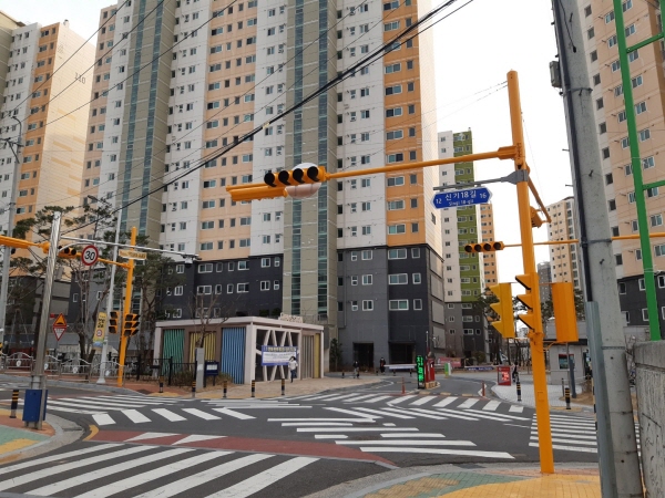 학교 앞 어린이 보호구역 내 신호등이 노란색으로 도색되어 있다.