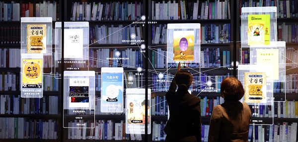 이날 국립중앙도서관 ‘실감서재(뉴미디어 체험관)’ 개관식에 참석한 관람객들이 3D 영상 대형 화면을 통해 수장고를 체험하고 있다.