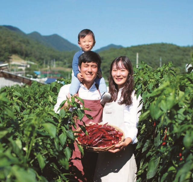 ▶'청년마을 만들기’ 프로그램에 참여한 청년 농부들이 자신들이 수확한 농작물을 들어보이고 있다. (사진제공= ㈜뭐하농)