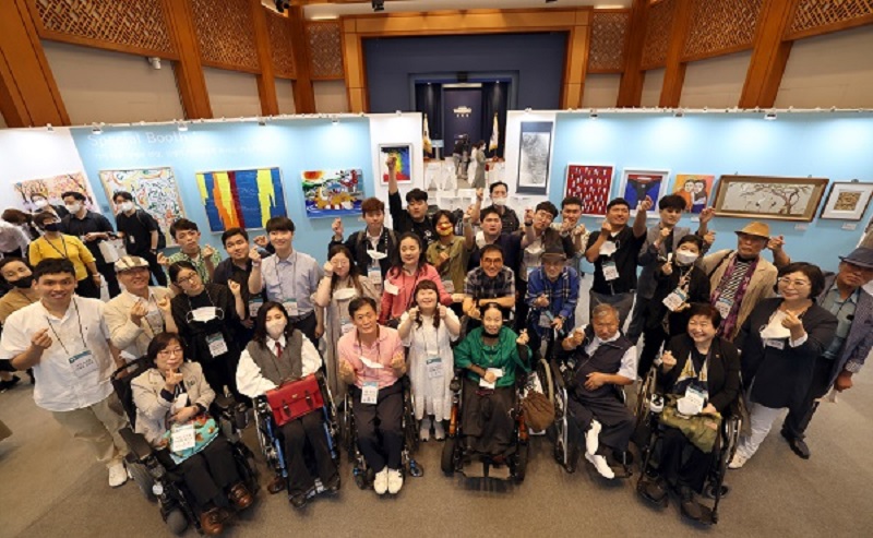 On August 31 last year, in the special exhibition of disabled artists, 'Into the People', which opened at the Cheongwadae Chunchugwan in Jongno-gu, Seoul, participating artists who have been active in their work despite developmental, physical, and hearing disabilities are taking a commemorative photo while drawing a heart.  (Photo = Ministry of Culture, Sports and Tourism)