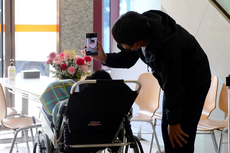 어버이날인 8일 오전 광주 북구 동행재활요양병원에서 한 가족이 입소 환자 어머니에게 카네이션을 건넨 뒤 손주 사진을 보여주고 있다.(사진=저작권자(c) 뉴스1, 무단 전재-재배포 금지)