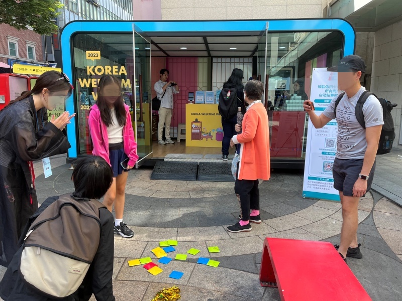 한국 방문의 해 환영 주간 명동 홍보 부스에서 딱지 치기를 하는 외국인 관광객