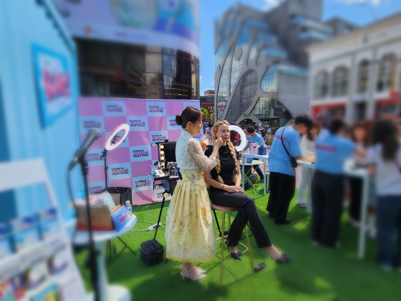 홍대 레드로드에서 아이돌 메이크업 시연쇼가 열리자 행인들이 모여들었다.