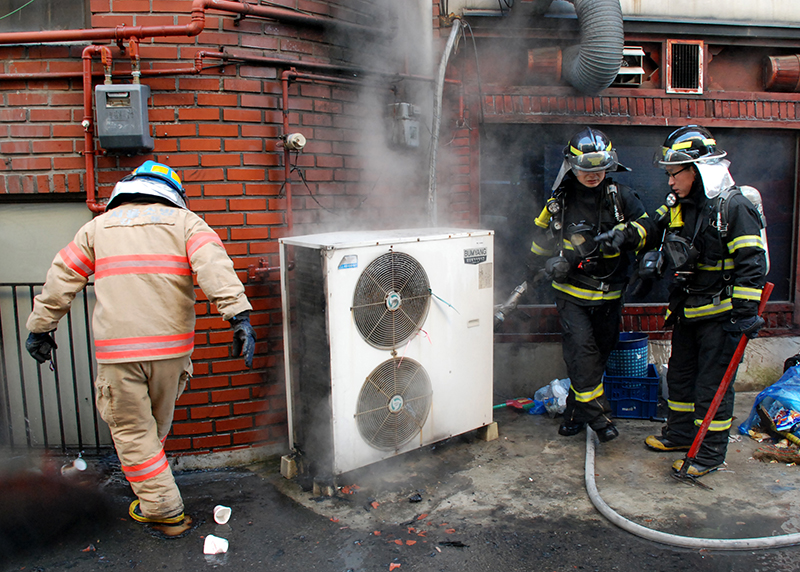 한 건물 실외기에서 화재가 발생해 소방관들이 불씨를 진압하고 있다. (ⓒ뉴스1, 무단 전재-재배포 금지)