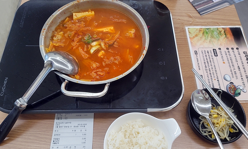 테이블마다 김치찌개를 맛있게 먹는 법이 적혀 있다. 가격에 놀라 영수증을 들고 왔다.