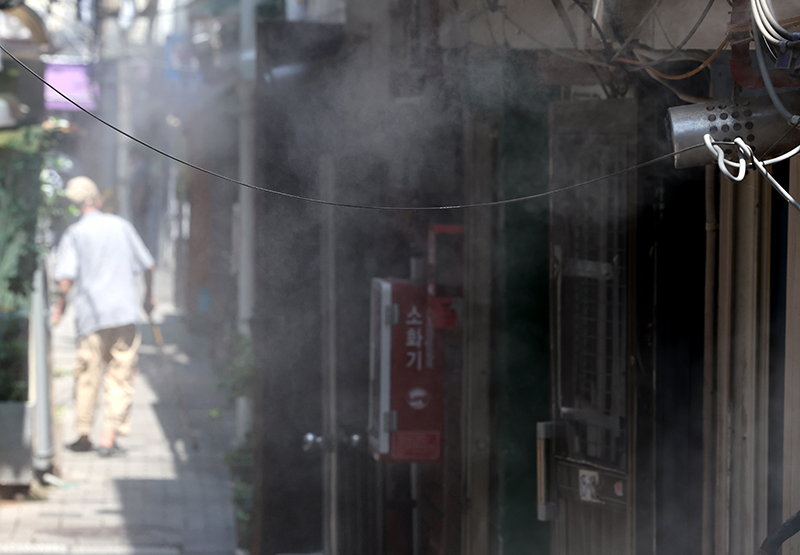 서울 종로구의 한 쪽방촌에서 주민들이 쿨링포그를 맞으며 더위를 식히고 있다. (ⓒ뉴스1, 무단 전재-재배포 금지)