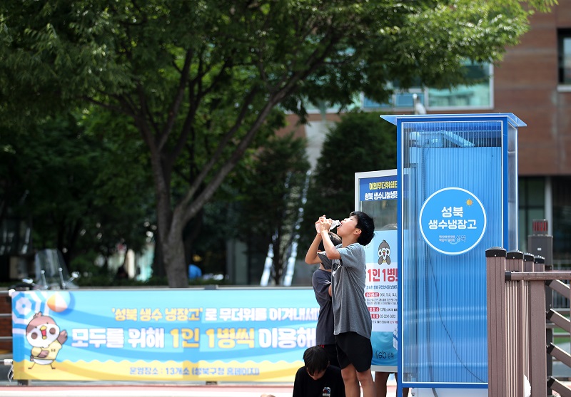 무더위가 기승을 부린 14일 오후 서울 성북구 바람마당에 설치된 ‘생수 나눔 냉장고’에서 학생들이 생수를 꺼내 목을 축이고 있다. 2024.7.14(ⓒ뉴스1, 무단 전재-재배포 금지)