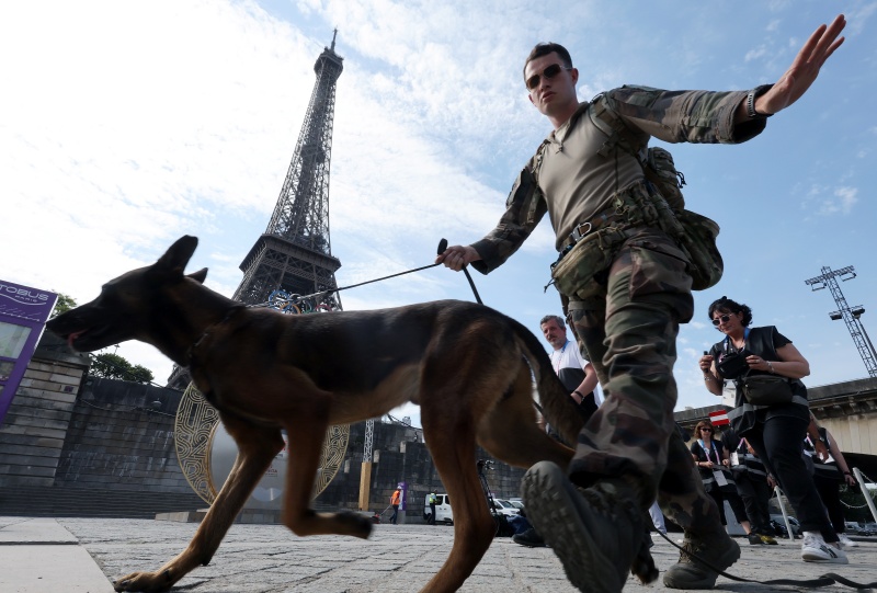 파리올림픽 개막을 일주일 앞둔 19일 오후(한국시간) 프랑스 파리의 에펠탑 아래 설치된 타임키퍼 앞으로 경찰 인력이 오가고 있다.(ⓒ뉴스1, 무단 전재-재배포 금지)
