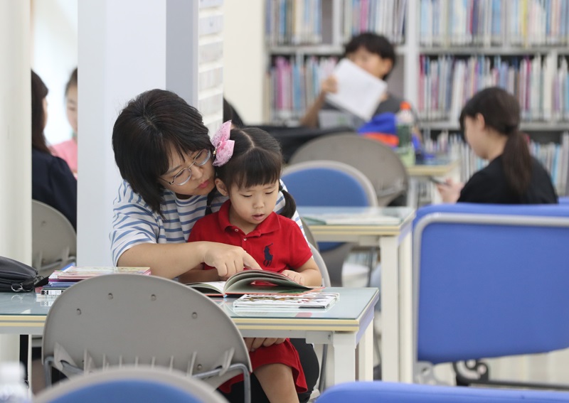 문화체육관광부는 6일 한국도서관협회와 함께 ‘2024년 전국 공공도서관 통계조사’ 결과를 발표했다. 사진은 지난 7월 30일 오후 경기 오산시 꿈두레도서관을 찾은 한 아이와 엄마가 여름 휴가철을 맞아 시원한 에어컨 바람 아래서 독서를 즐기고 있다.  (ⓒ뉴스1, 무단 전재-재배포 금지)