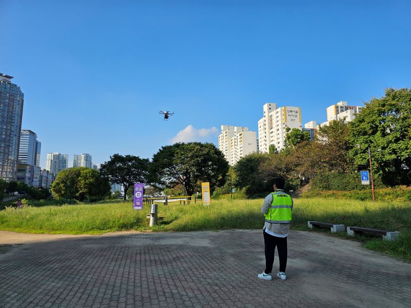 내가 배송한 물건이 드론에 실려 낙하지점으로 향하고 있다. 담당 직원은 안전한 배송을 위해 현장에서 조종하는 모습을 보여줬다.