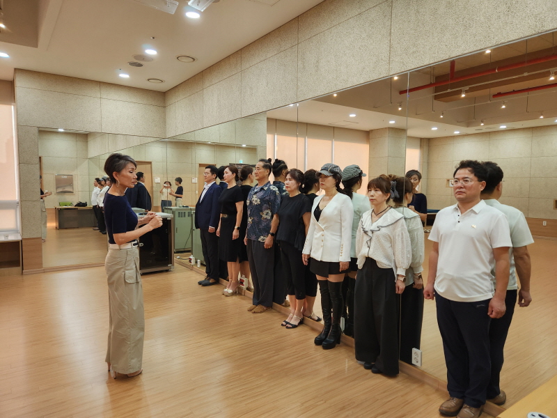 허미숙 강사가 수강생들을 벽면에 일렬로 세운 뒤 모델로서의 기본 자세를 알려주고 있다.