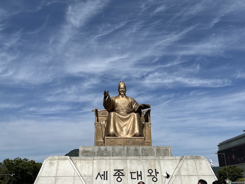 광화문 광장에 세워진 세종대왕 동상의 모습. 세종대왕 동상 앞에서 많은 관광객들이 한글에 대한 문화 해설을 들으며 기념 사진을 찍고 있다.