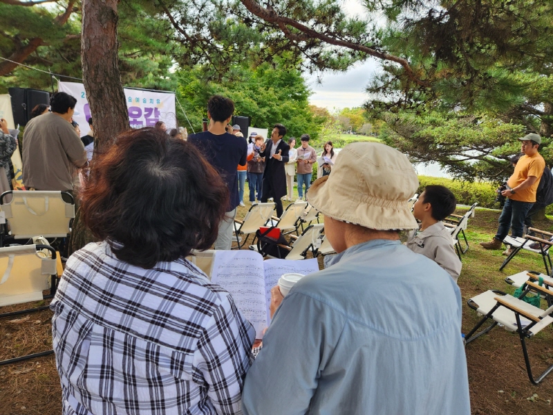 일산호수공원을 산책하다가 노랫소리에 이끌려서 이곳에 온 부부도 악보를 보면서 합창하고 있다.