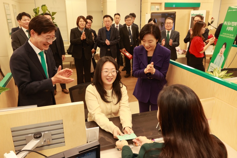 오영주 중소벤처기업부 장관이 13일 서울 양천구 하나은행 강서금융센터지점에서 ‘중소기업 재직자 우대 저축공제’ 에 1만번째로 가입한 중소기업 재직자를 축하하고 있다.(제공=중소기업벤처부)