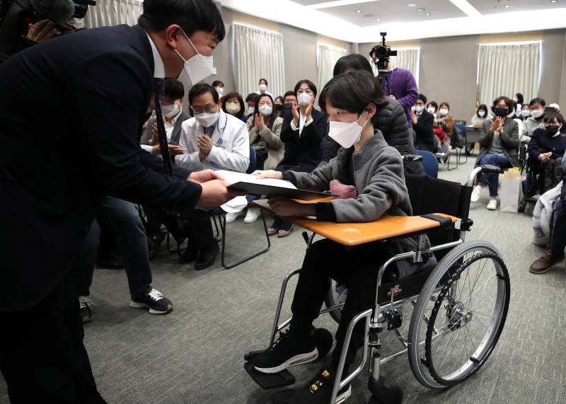 지난해 2월 16일 오후 서울 연세대 강남세브란스병원에서 열린 ‘한국의 호킹들, 축하합니다’ 행사에서 신경근육계질환 장애를 극복하고 대학교에 입학한 학생이 장학증서를 받고 있다.(ⓒ뉴스1, 무단 전재-재배포 금지)