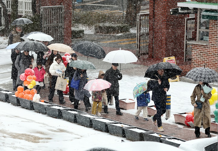 4일 서울 마포구 아현초등학교에서 열린 입학식에서 신입생 가족이 눈을 맞으며 강당으로 향하고 있다. 2025.3.4(저작권자(c) 연합뉴스, 무단 전재-재배포 금지)